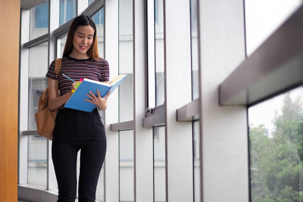 istock Asian students stand reading books in the university library. 1488085047