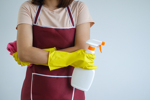Close-up of a woman's body with cleaning equipment.