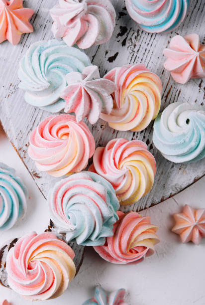 istock Multicolored meringue on wooden tray top view 1488090675
