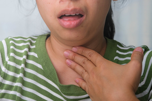 Young woman touching painful throat, sore throat flu, cold and infection. Medical and healthcare concept.