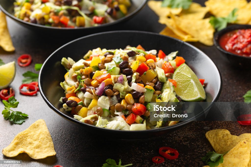 Mexican style salad of black beans, lentils, corn, tomato and lettuce with a salsa and tortilla chips Mexican style salad of black beans, lentils, corn, tomato and lettuce with a salsa and tortilla chips. Lentil Stock Photo