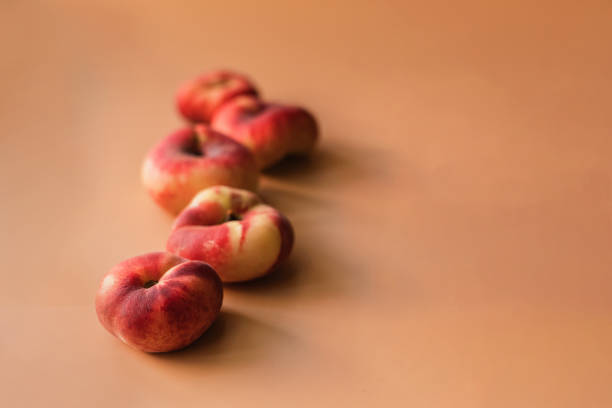 peaches donuts lie in a row on a peach background, perspective view