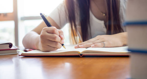istock Female students writing and reading in the library 1488097433