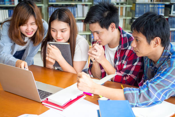 istock Multiethnic college students checking test results, looking at laptop screen at library. 1488097464