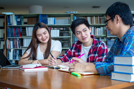 A group of students or university students enjoy studying in the college library.