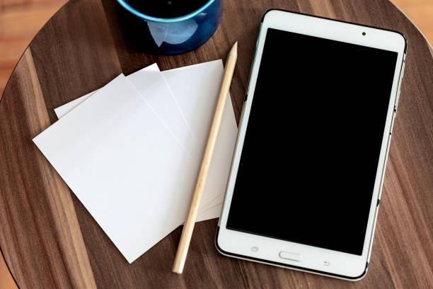 blank paper, notepad and coffee cup on wooden background