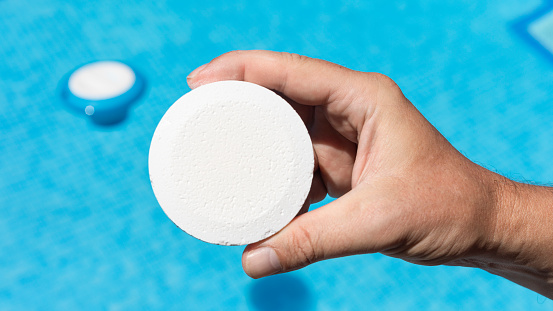 Pool cleaner with chlorine tablets to have optimal water quality for bathing in summer. White chlorine tablets for swimming pools to control the PH of the water.
