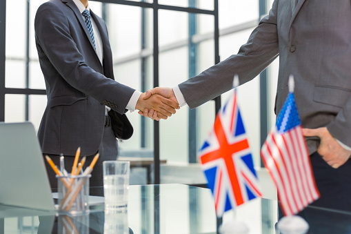 United Kingdom and American leaders shaking hands on a deal agreement