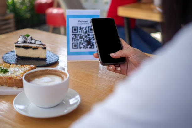 istock Women's hands are using  the phone to scan the qr code to select food menu. Scan to get discounts or pay for food. The concept of using a phone to transfer money or paying money online without cash. 1488101610