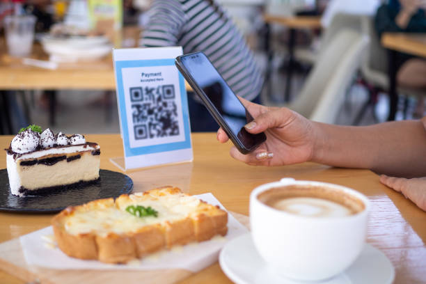 istock Women's hands are using  the phone to scan the qr code to select food menu. Scan to get discounts or pay for food. The concept of using a phone to transfer money or paying money online without cash. 1488101612
