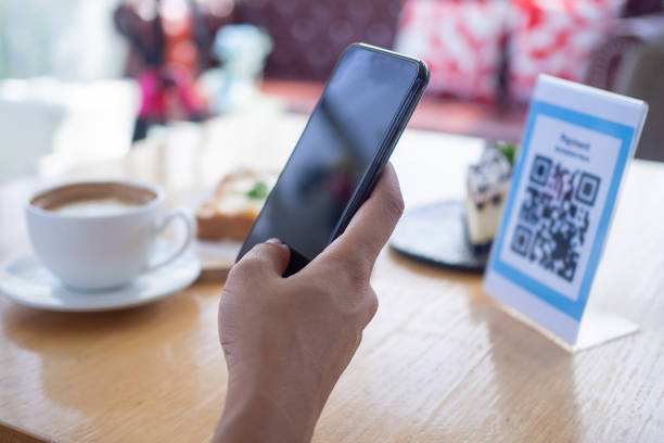istock Women's hands are using  the phone to scan the qr code to select food menu. Scan to get discounts or pay for food. The concept of using a phone to transfer money or paying money online without cash. 1488101636
