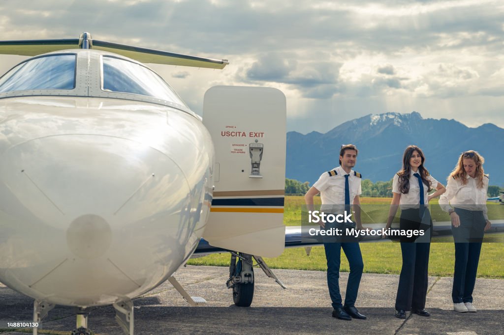 Pilots posing in front of private airplane Private plane business travel 20-24 Years Stock Photo