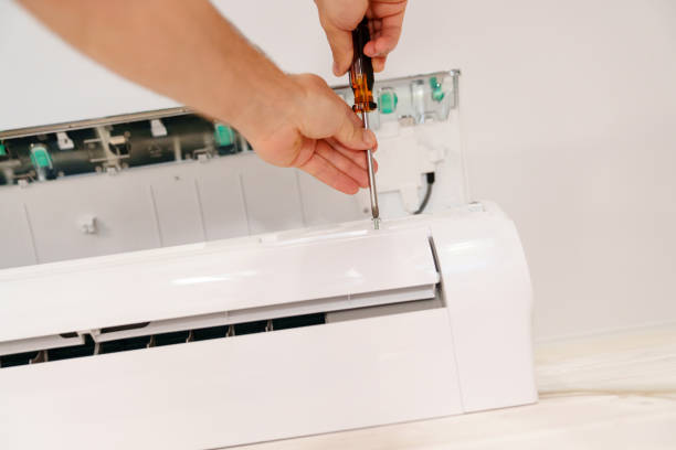 istock A man unscrews an air conditioner on the wall with a screwdriver 1488106525