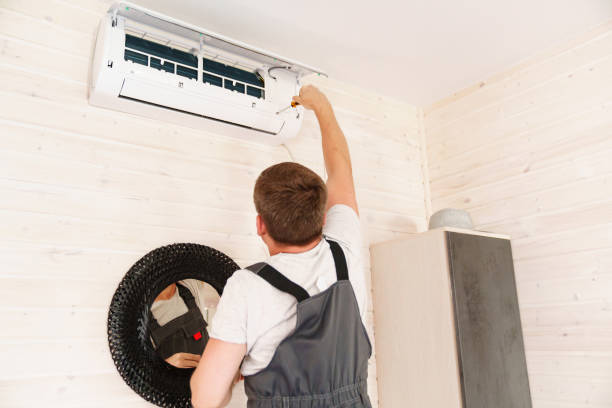 istock A man unscrews an air conditioner on the wall with a screwdriver 1488106568