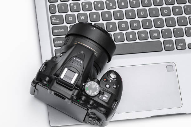 istock Photo camera lying on a laptop on a white background 1488109236