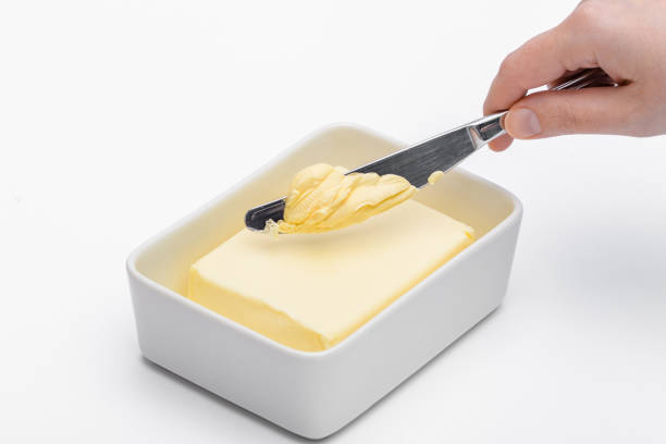 istock Spread butter in a churn, knife over a cube of margarine 1488110170