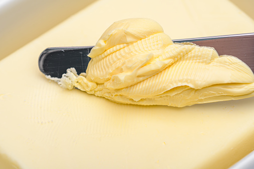 Spreading, using a stick of butter on a knife full of spreads macro close-up