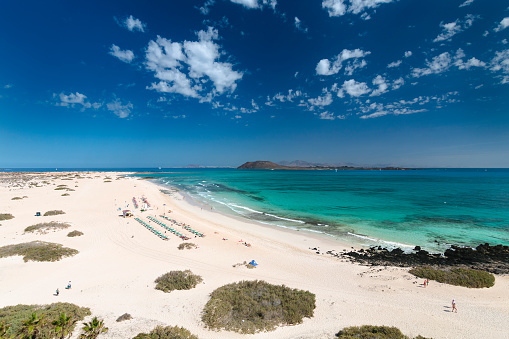Aerial view of Corralejo beach and dunes with turquoise water in Fuerteventura, Spain with Isla de Lobos and Lanzarote in the background.