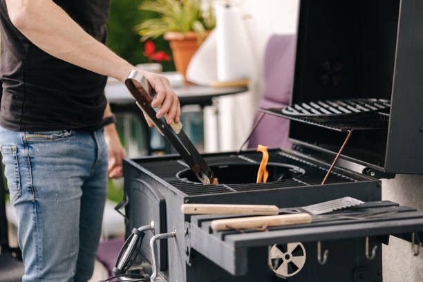 istock Close-up of man make a fire and controls the process. BBQ grill outdoor 1488111901