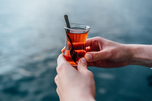 Female hands holding traditional Turkish tea in Istanbul, Turkey