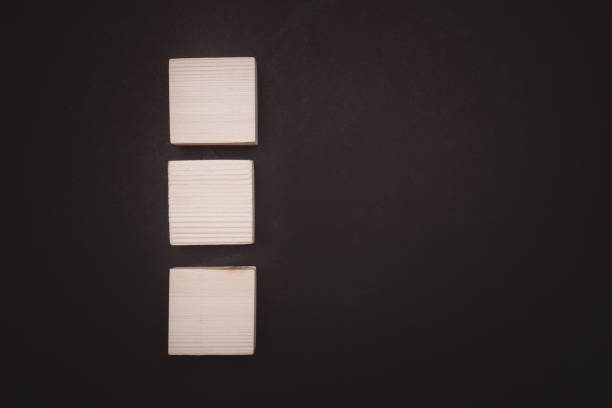 istock Overhead view of blank three wooden cubes on a black background with space for text. 1488115140