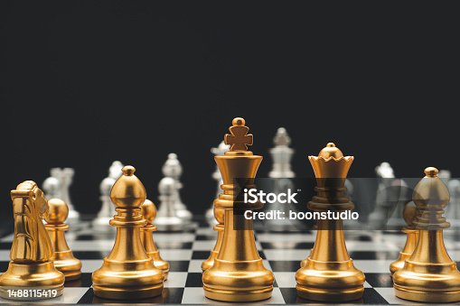 istock Chess pieces on board game on black background. 1488115419