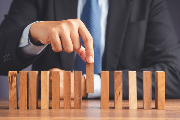 istock A businessman pick up a wooden block while sitting in the office 1488116607