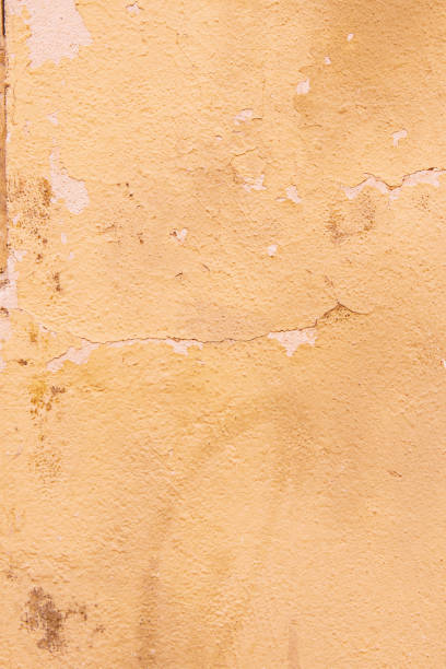 surface rugueuse d’un mur avec une peinture écaillée de couleur jaune crème pâle - paint rough peeling grunge photos et images de collection