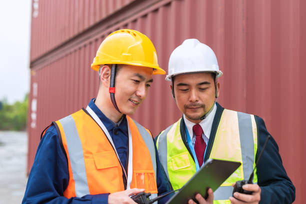 istock Two Asian container yard managers work in the yard management 1488118221