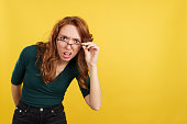 Redheaded woman with glasses staring at the camera in disbelief