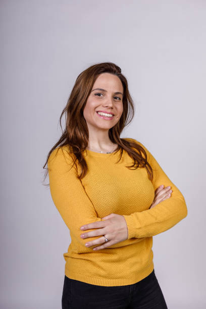 istock Charming young woman standing against white background, cheerfully smiling at camera 1488119909