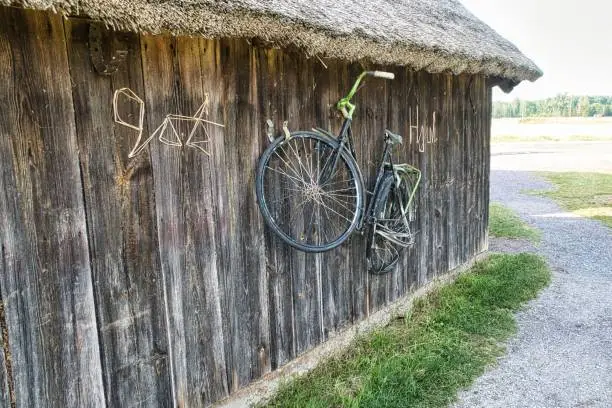 An antique bicycle suspended from a wooden shed