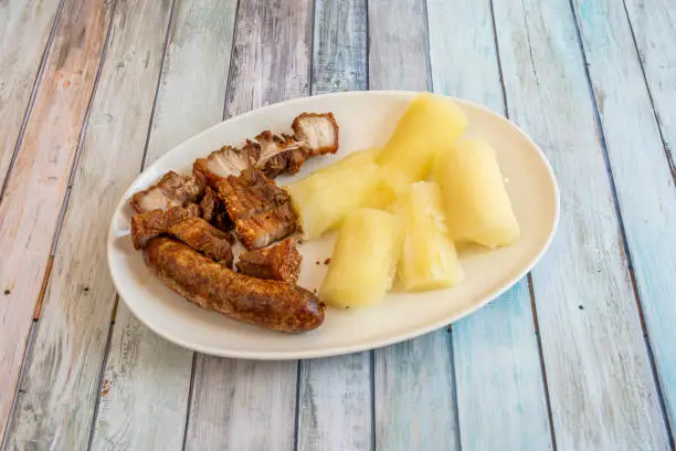 Photo of pieces of fried pork rinds with fried chorizo and fried yucca served in an Ecuadorian restaurant