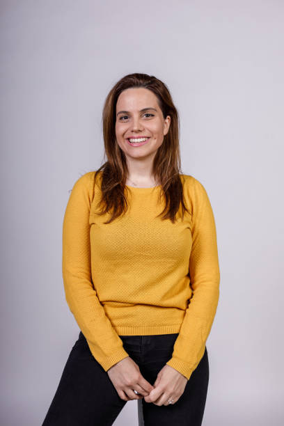 istock Charming young woman sitting against white background, joyfully smiling at camera 1488121416