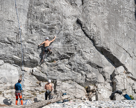 Banff National Park, Alberta, Canada – May 06, 2023: Three men engage in climbing a rock face