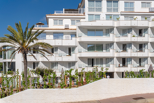 Portocolom, Spain; april 23 2023: Facade of a white tourist hotel in the Majorcan town of Portocolom, Spain
