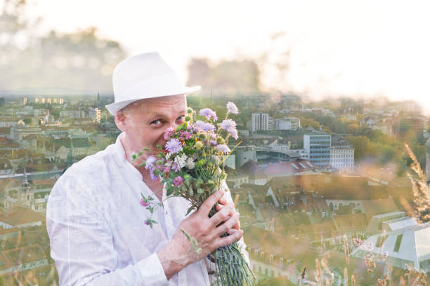 Mature man looking a flower on kitchen at home