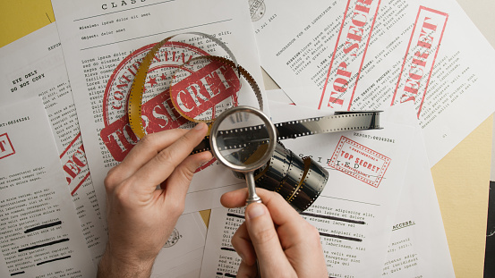 Magnifying glass shows confidential film.