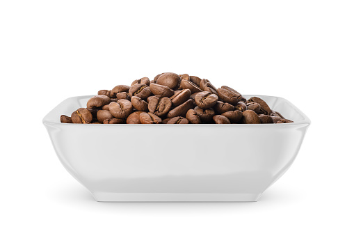 Roasted coffee beans in white bowl isolated on white background. Front view.