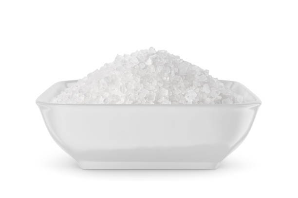 istock Coarse sea salt in white bowl isolated on white. Front view. 1488129509