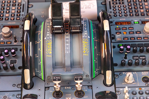 cockpit view of instruments of a commercial jet airliner with pilot in cruise phase of flight.