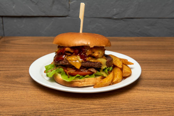 istock Mixed burger with beef fillet with tomato, stewed onion, melted cheddar cheese, battered chicken fillet and ketchup and mustard sauce 1488133563