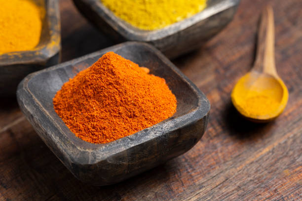 istock Turmeric, pepper and curry powder in container on wooden background 1488137232