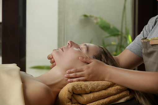 Face massage, a woman in the spa having anti-age face massage