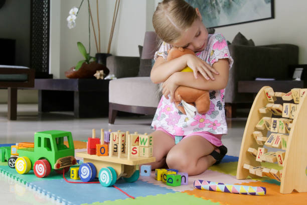 istock Adorable little girl hugging her teddy bear 1488141817