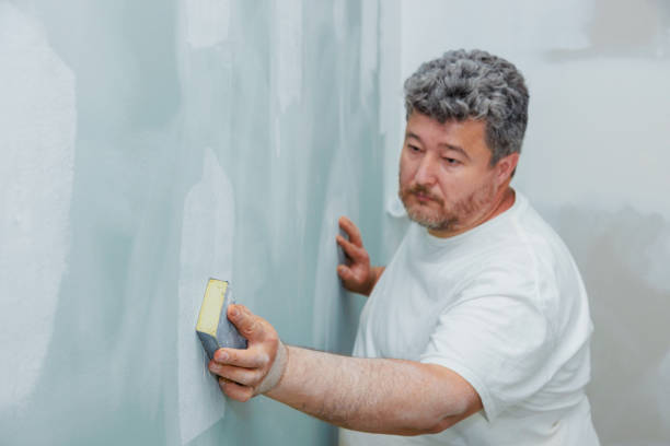 Contractor sanding the wall after putty during repair, improvement apartment room Contractor sanding wall after putty during repair, improvement apartment room sand paper stock pictures, royalty-free photos & images