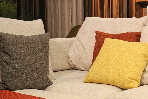 Close-up of comfortable colorful soft pillows on sofa. Stylish trendy apartment home decor. Hygge scandinavian loft design. Interior of modern bedroom in hotel. Comfort sleep and relax concept.