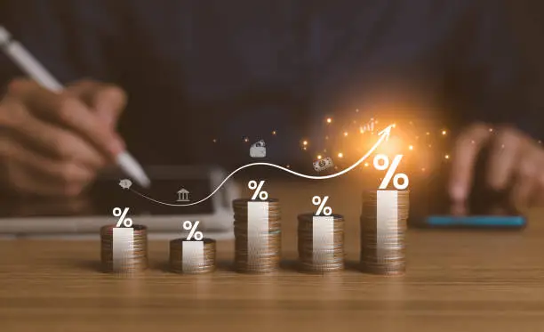 Photo of interest rates and dividends, investment returns, income, retirement Compensation fund, investment, dividend tax. pile of coins and upward direction percentage symbol. saving money for investment