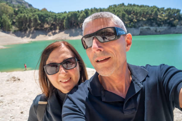 istock A happy couple relaxing along a beautiful lake 1488158329
