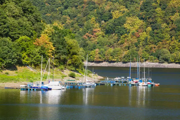 Lake Rursee marina in Rurberg in the Eifel, Germany on a summer day with colorful trees.